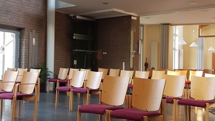 Modernes Café mit hohen Decken und Holzstühlen