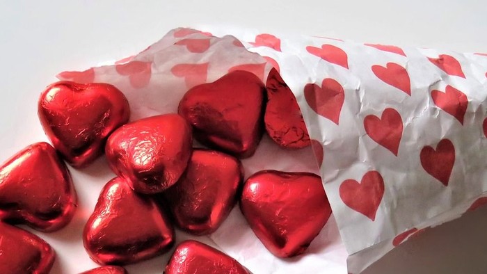 Herzförmige Schokoladenstücke in rotem Folienpapier