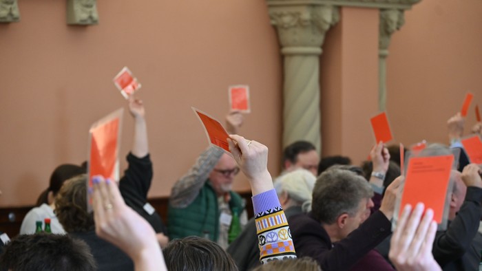 Eine Menge hebt gleichzeitig rote Karten bei einer Veranstaltung oder Versammlung.
