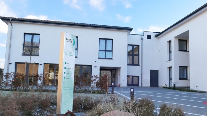 Modernes Gebäude mit Garten und Parkplatz