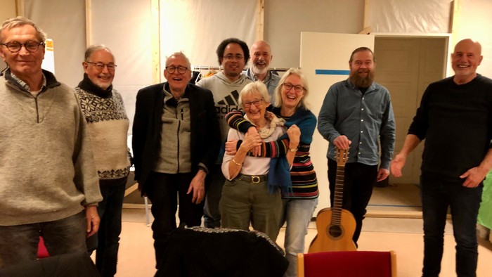 En gruppe af mennesker samlet sig i et rum med guitarer