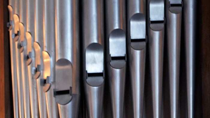 En fløjteorgel med mange metalrør i forskellige størrelser.