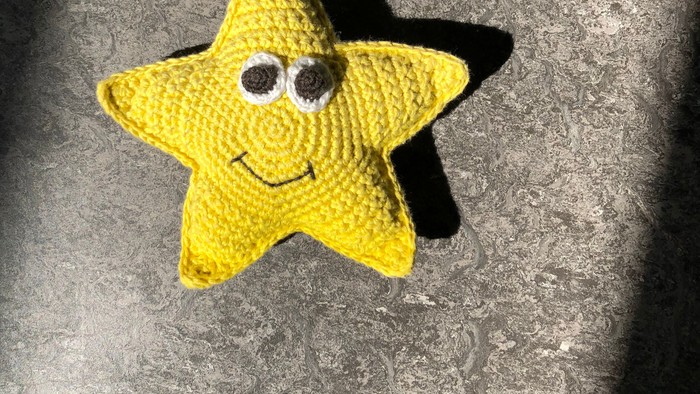En gult stjernetøj med ansigt og sort hale.
