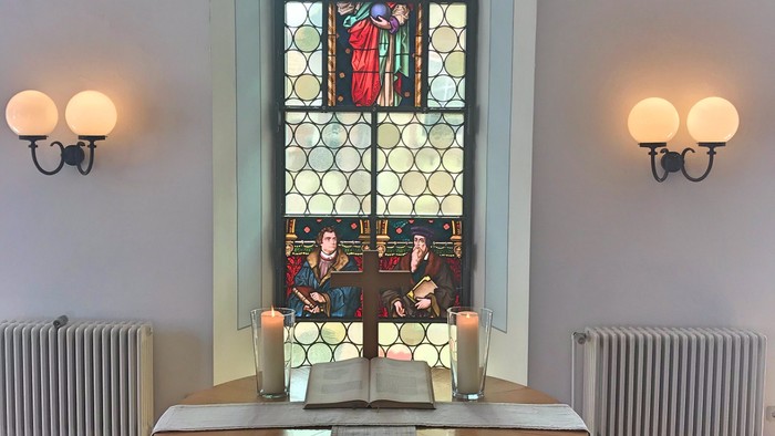 Ein Kirchenaltar vor einem buntglasfenster