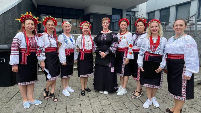 Gruppe von Frauen in traditioneller Kleidung, die gemeinsam posieren.