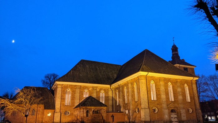 Grosses, beleuchtetes Kirchengebäude bei Nacht mit klarem Himmel