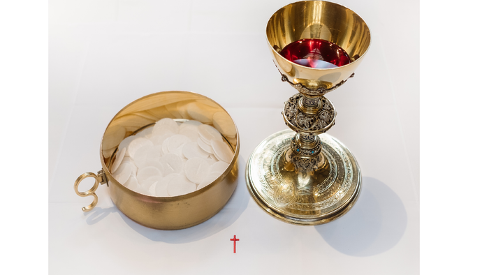 Gold chalice and paten with host, symbolizing Eucharist
