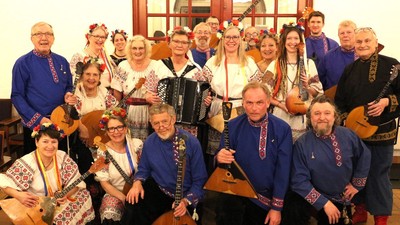 Traditionelt folkemusikorkester i farverige nationale dragter, der spiller på forskellige instrumenter sammen.