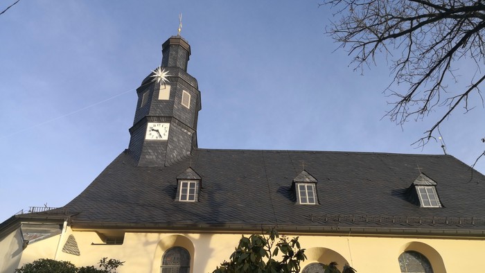 Kirche mit Uhrturm und Bogenfenstern.