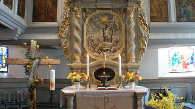Kirchenaltar mit Blumen und Orgel