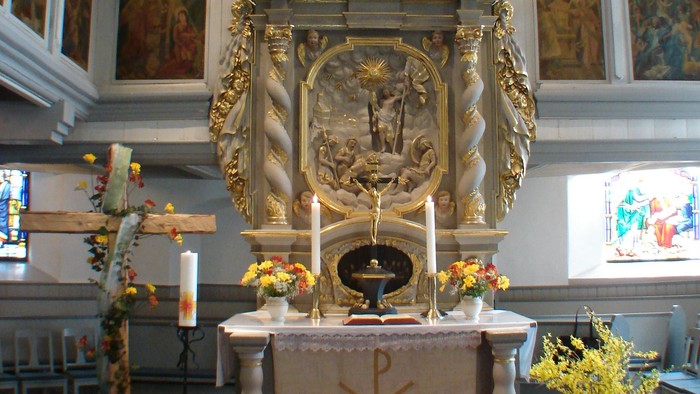 Kirchenaltar mit Blumen und Orgel