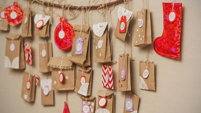 Eine Wanddekoration mit vielen kleinen Geschenkpäckchen und Weihnachtsornamenten.