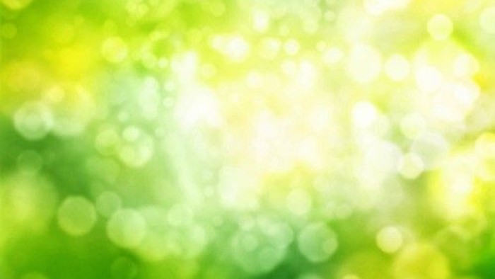 Ein verschwommenes Bild mit grünen und gelben Farbtönen und Lichtflecken