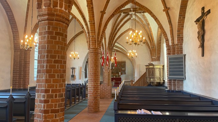 Indvendig billede af Eggeslevmagle Kirke med ophængte Dannebrog-flag