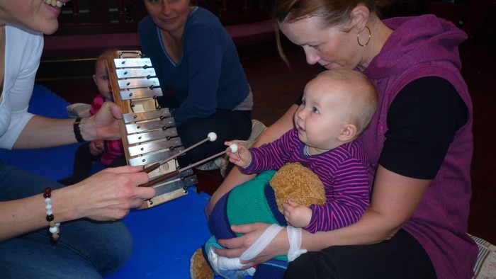 En gruppe af voksne og et barn spiller på marimba