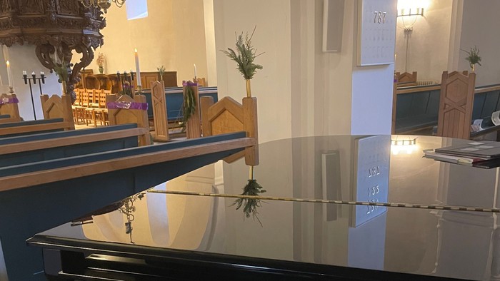 Flygel med advent-pynt i baggrunden