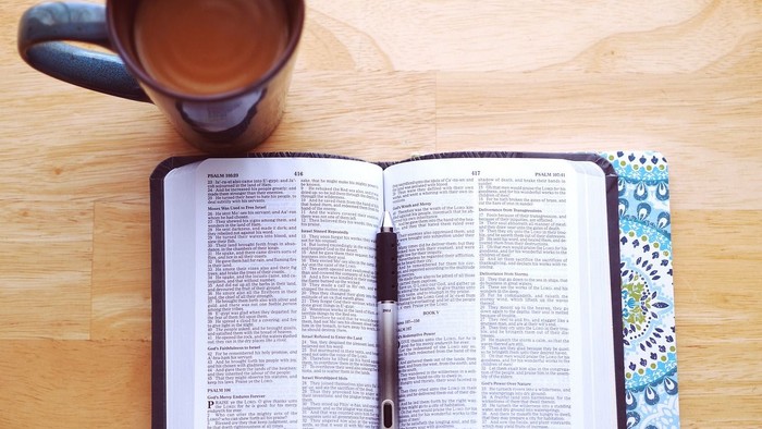 Bibel geöffnet, daneben eine Tasse Kaffee