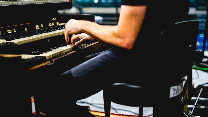 Eine Person spielt auf einem schwarzen Keyboard.