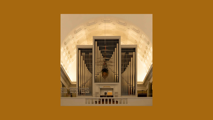 Et stort orgel i en stor sal med arkitektoniske detaljer.