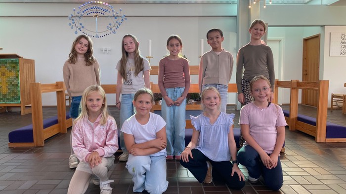 En gruppe børn poserer sammen i en kirke.
