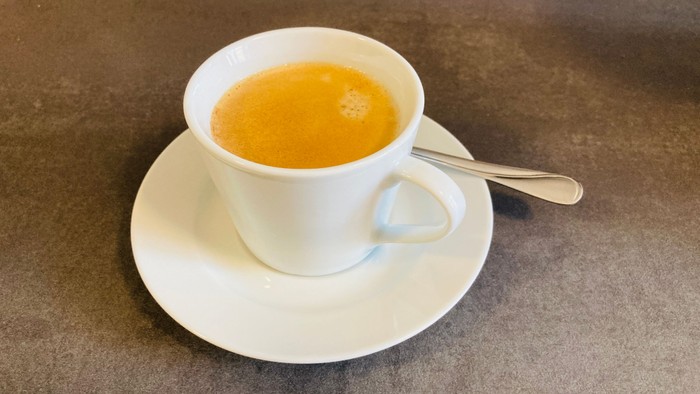 Eine Tasse Tee auf einem Unterteller mit Löffel