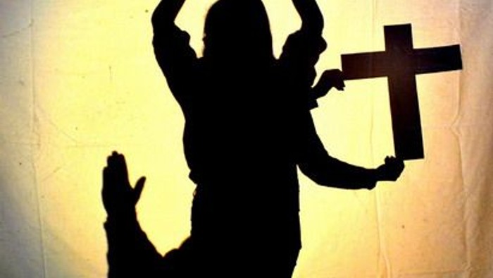 Schatten einer Person mit Kreuz und Herzzeichen