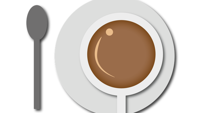 Eine Tasse Kaffee mit einem Löffel daneben