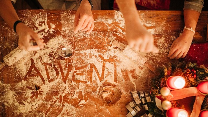 Menschen, die ein Spiel mit Würfeln und Holzklötzen spielen, das Wort *„ADVENTURE“* steht auf dem Tisch.