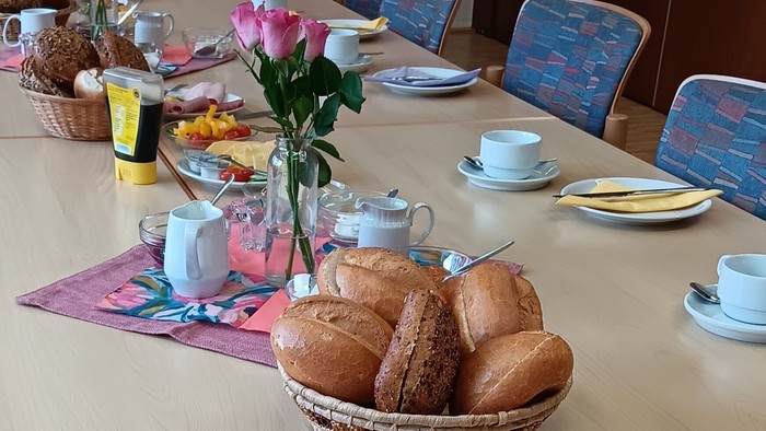 Frühstückstisch mit Brot, Wurst, Gemüse und Tee