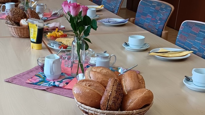 Frühstückstisch mit Brot, Wurst, Gemüse und Tee