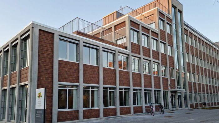 Moderne kontorbygning med røde mursten og store vinduer