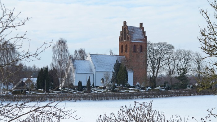 En kirke med tårn ved en frossen sø