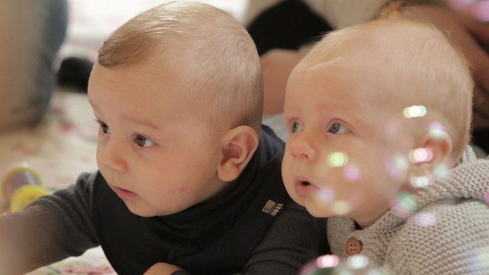 To børn ligger på magen og kigger op.