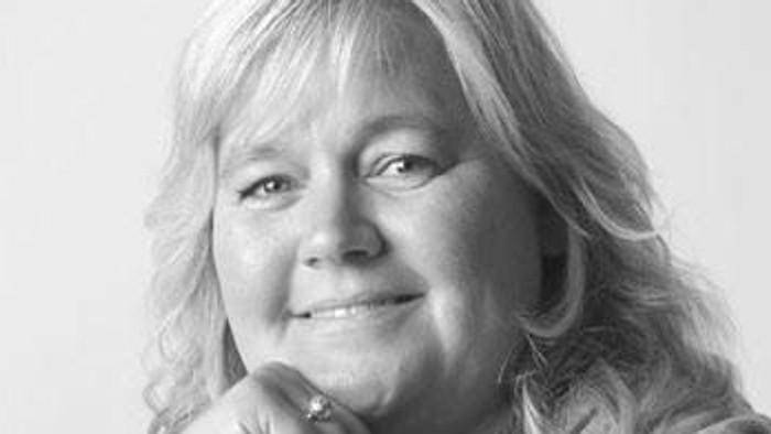 En kvinde med blondt hår og en blød udtryk.