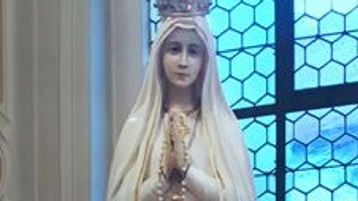 Heilige Statue in Kirche mit Blumen und Kerzen