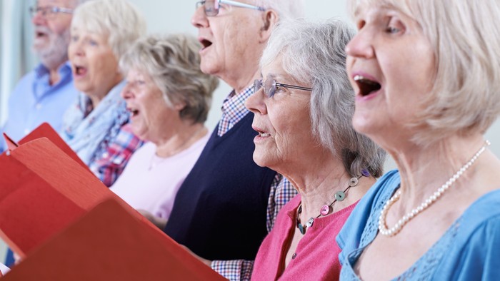 En gruppe ældre damer synger i kor.