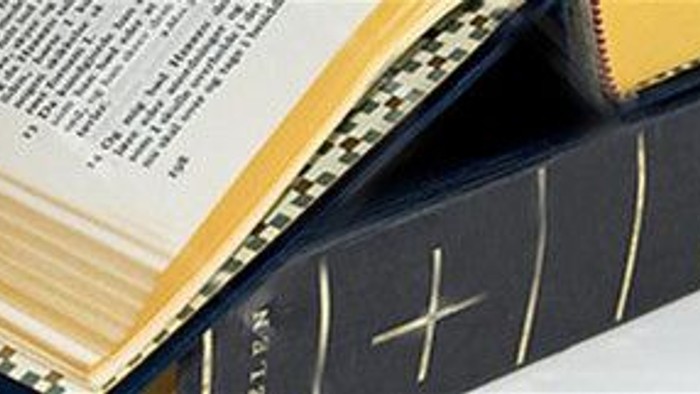 En blå bog med guldforgyllet kant og guldtryk på ryg.