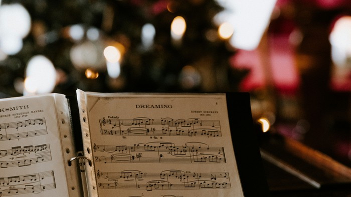 Notenbuch liegt auf dem Klavier, Weihnachtsbaum im Hintergrund