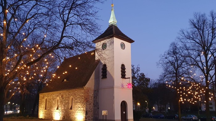 Kirche, die nachts mit Lichterketten an den Bäumen beleuchtet ist
