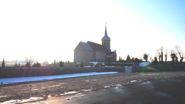 En kirke med tårn ved en frossen sø.