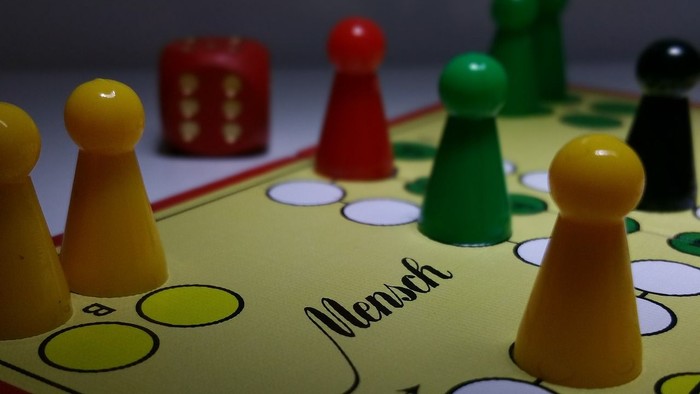 Das Bild zeigt ein Gesellschaftsspiel mit verschiedenen Spielfiguren und einem Spielbrett.