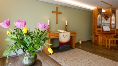 Kircheninneres mit Blumen, Kreuz und Orgel