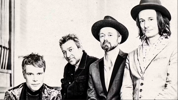 Fire mænd i mørke hatter og formelle klæder.