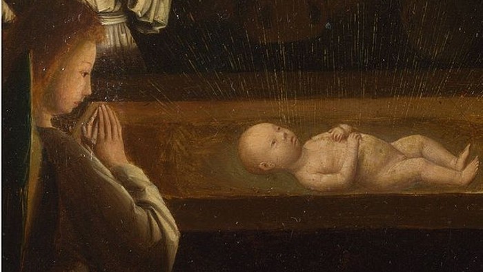 En kvinde ser på et sovende barn i en kiste