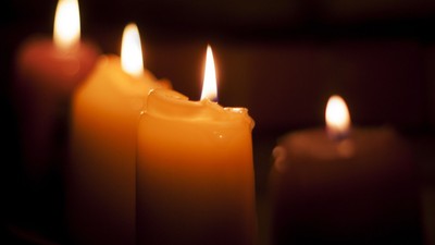 Fire tændte stearinlys i en mørk omgivelse.