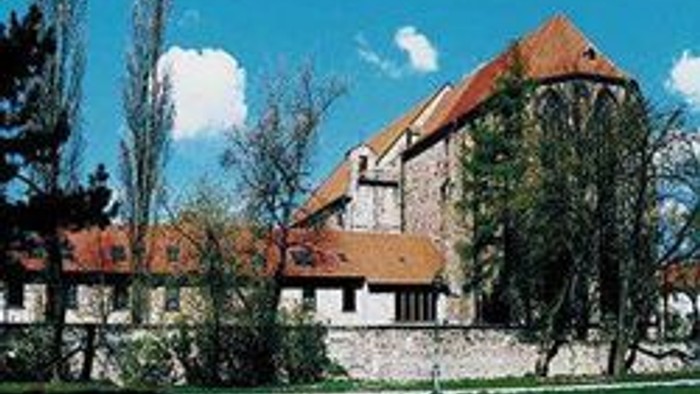 Ein großes Gebäude mit rotem Dach und grünem Rasen davor