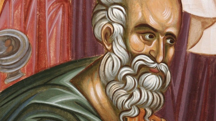 Skægget mand, der holder en rulle, iført en grøn kjortel