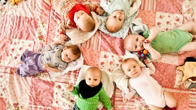 Børn og tøjpudder ligger på en blomsteret dekke