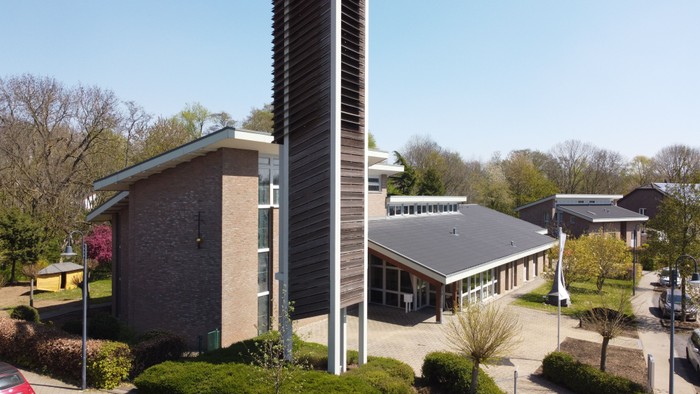 Das Bild zeigt ein modernes Gebäude mit Glasfassade und umliegender Grünfläche.