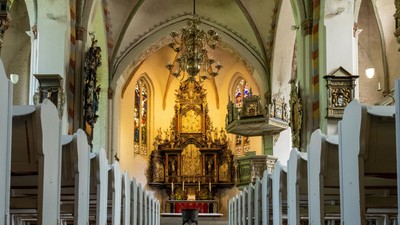 Innenraum einer Kirche mit Altarraum und Kronleuchter